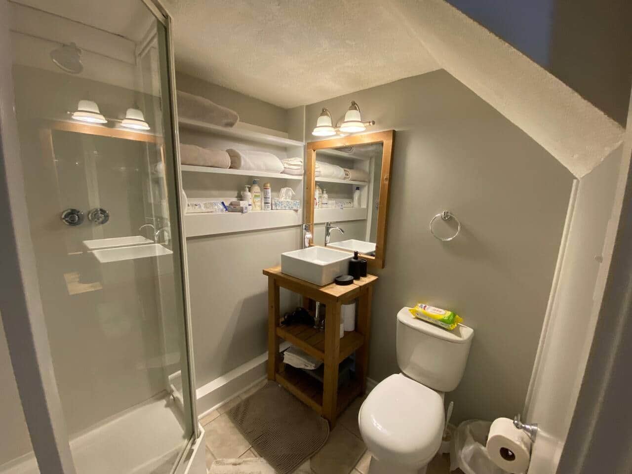 Private bathroom with a glass shower, vessel sink, and toilet