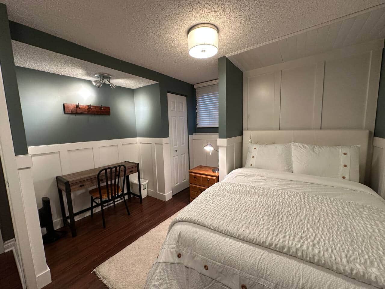 Bedroom with a made bed, writing desk, and chair
